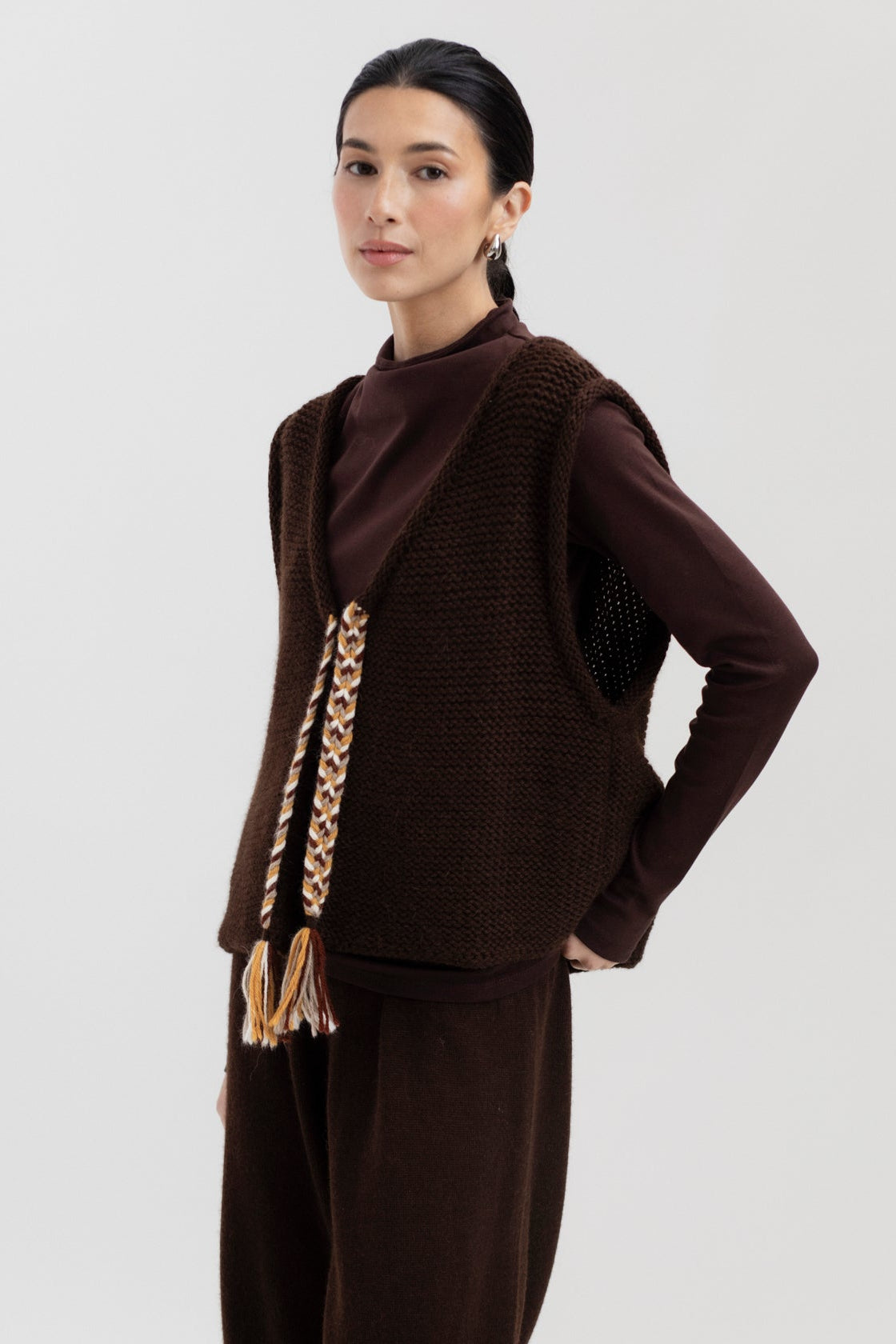 Vela Braid Vest in Chocolate Brown, baby alpaca knit vest with hand-braided trim by Ahblo, worn by model