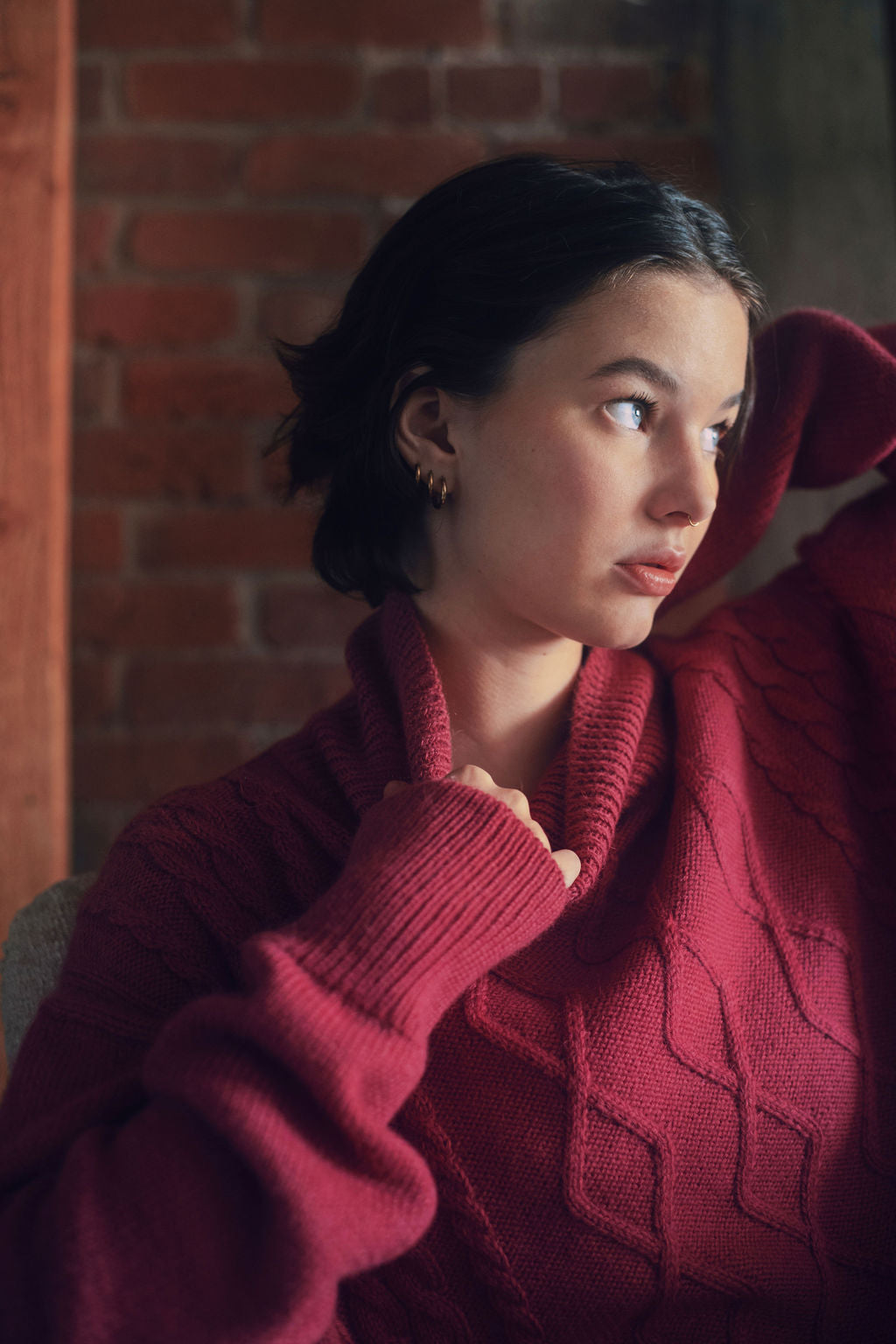 Model wearing oversized cable knit sweater in hot pink alpaca wool, close-up