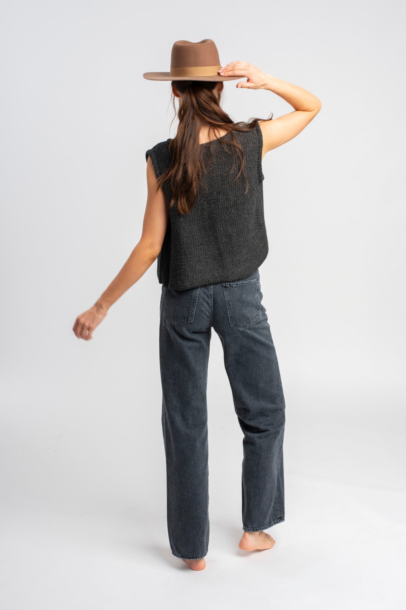 Model wearing dark grey knit vest in alpaca wool, back