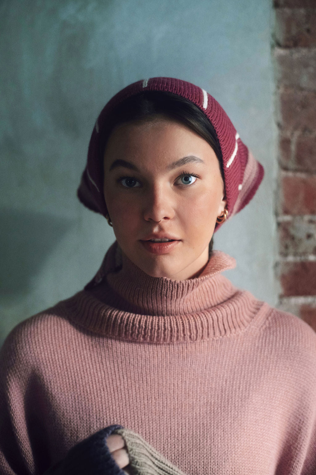Model wearing knitwear alpaca wool headscarf in white & pink, front