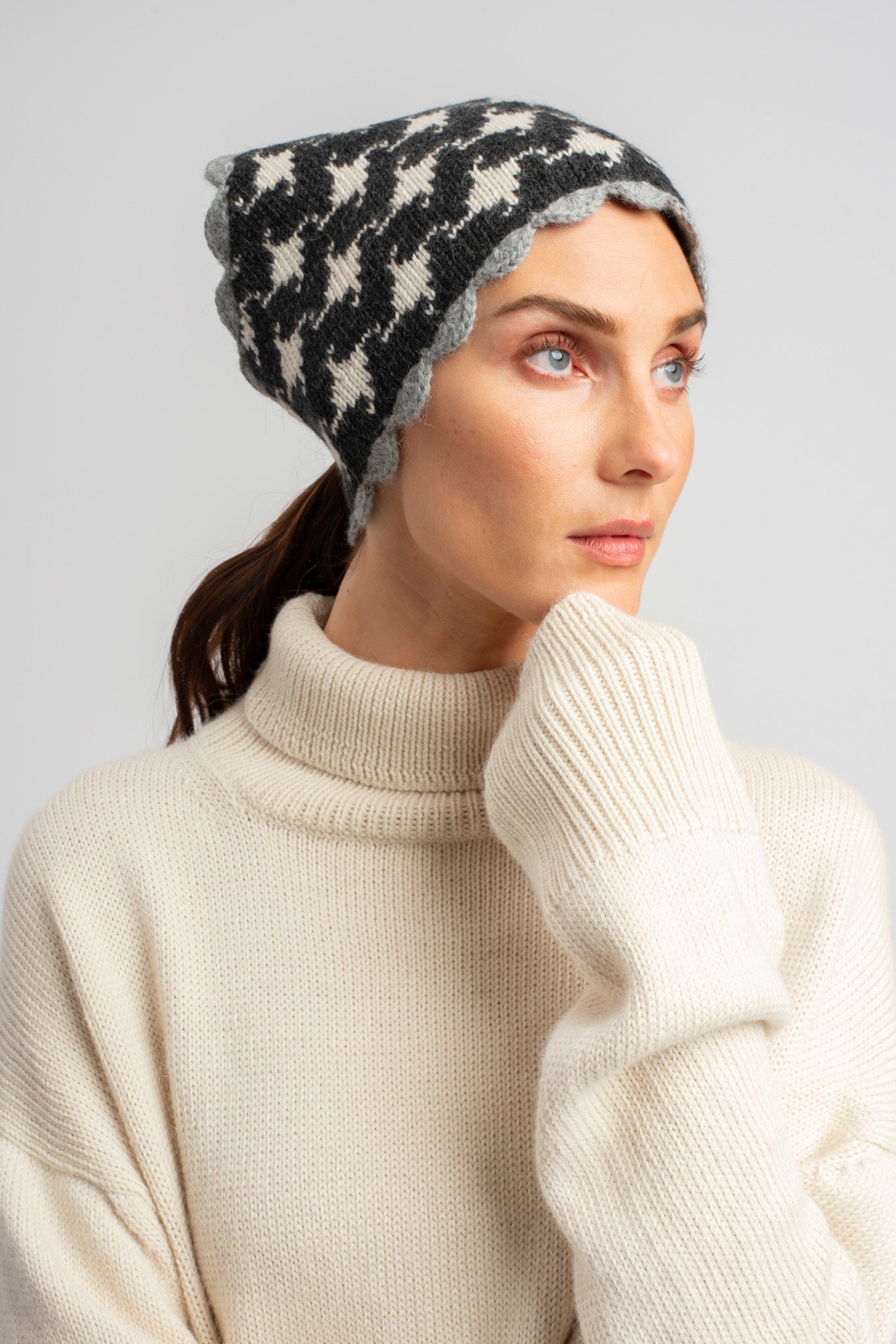 Model wearing knitwear alpaca wool headscarf in white & grey reversible houndstooth