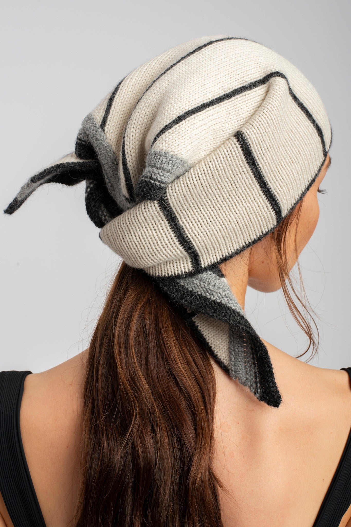 Model wearing knitwear alpaca wool in white & grey reversible stripes, back