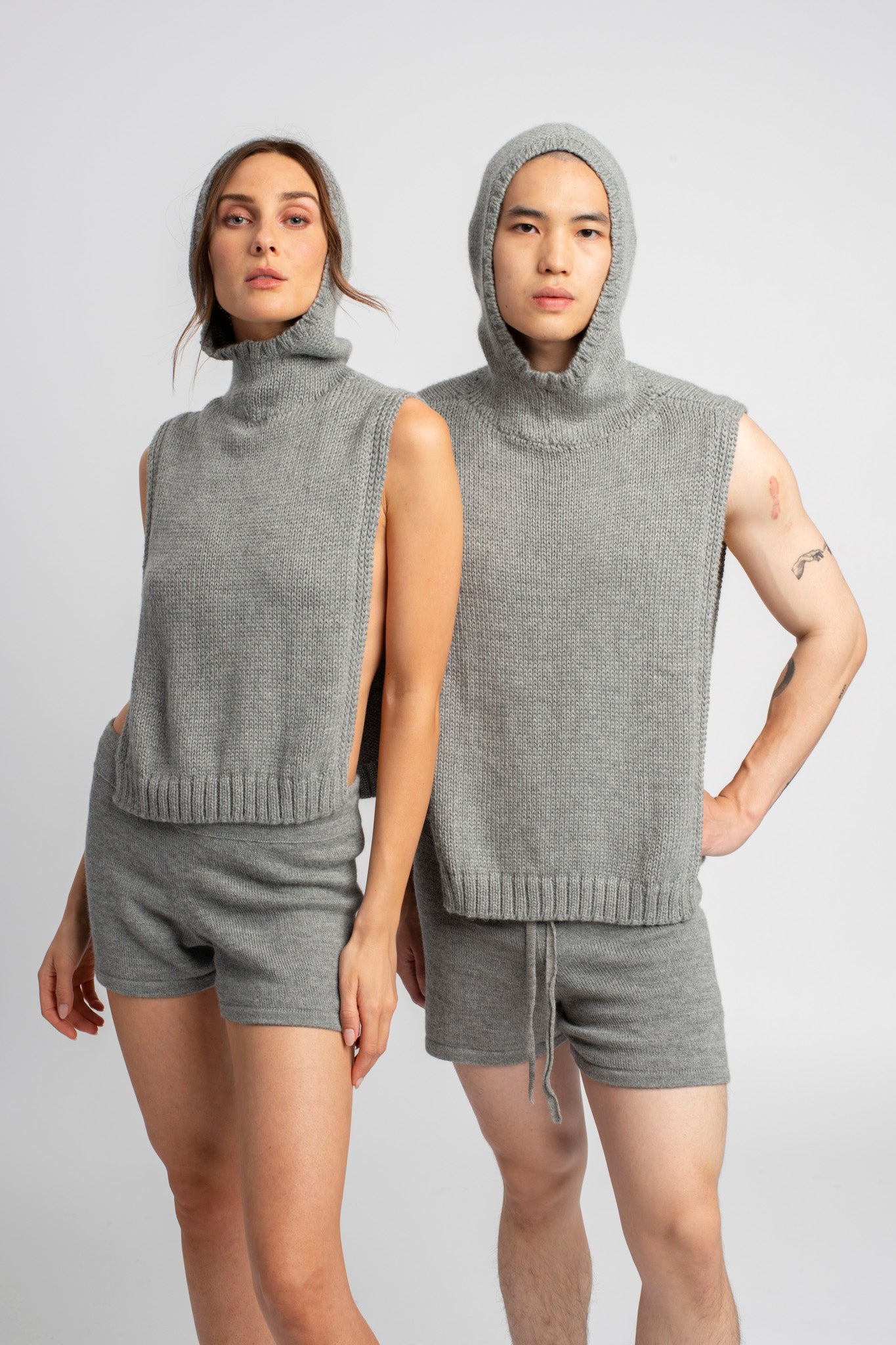 Two models wearing poncho in light grey alpaca wool wearing hoods facing forward