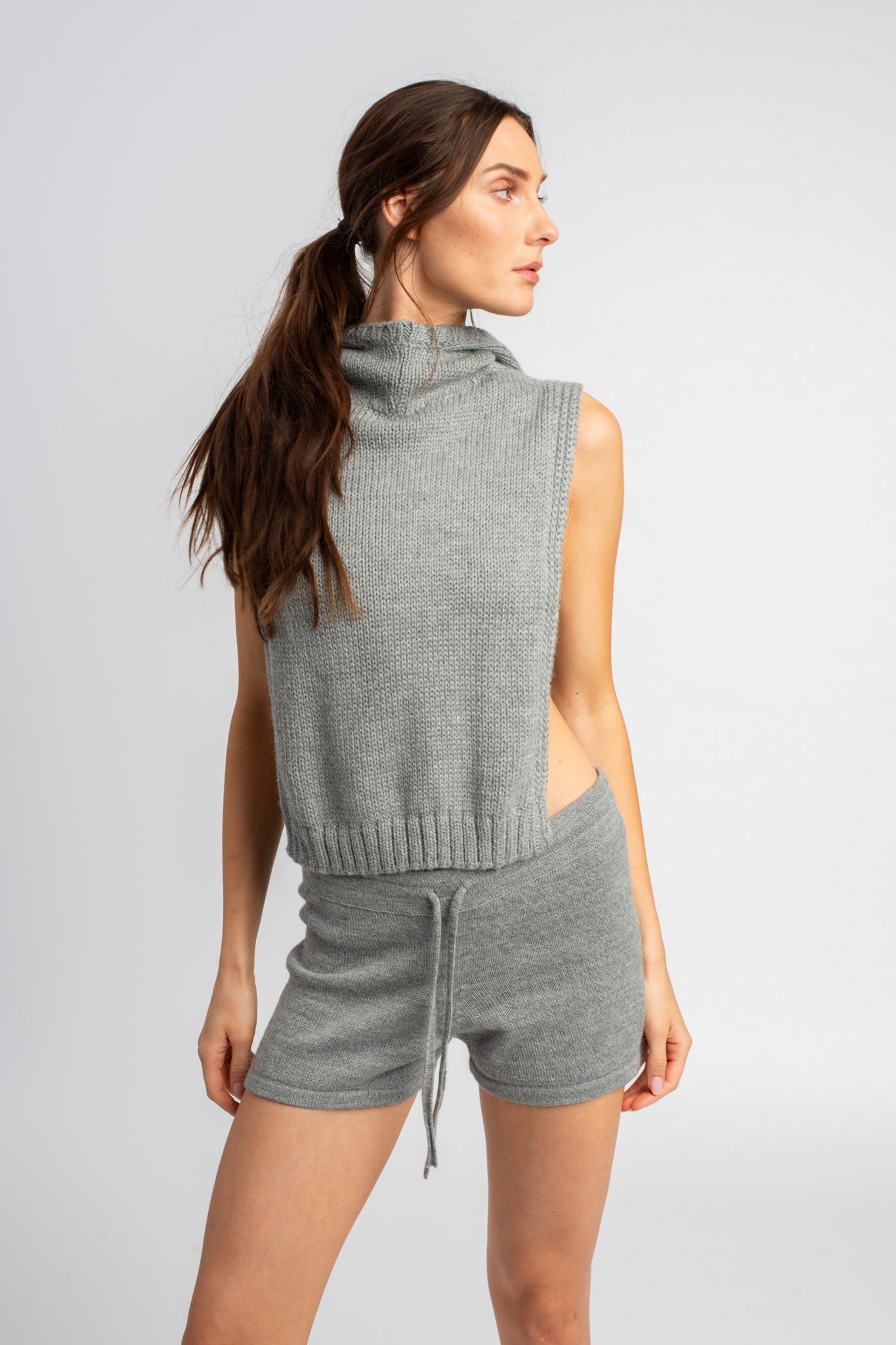 Model wearing poncho in light grey alpaca wool, standing