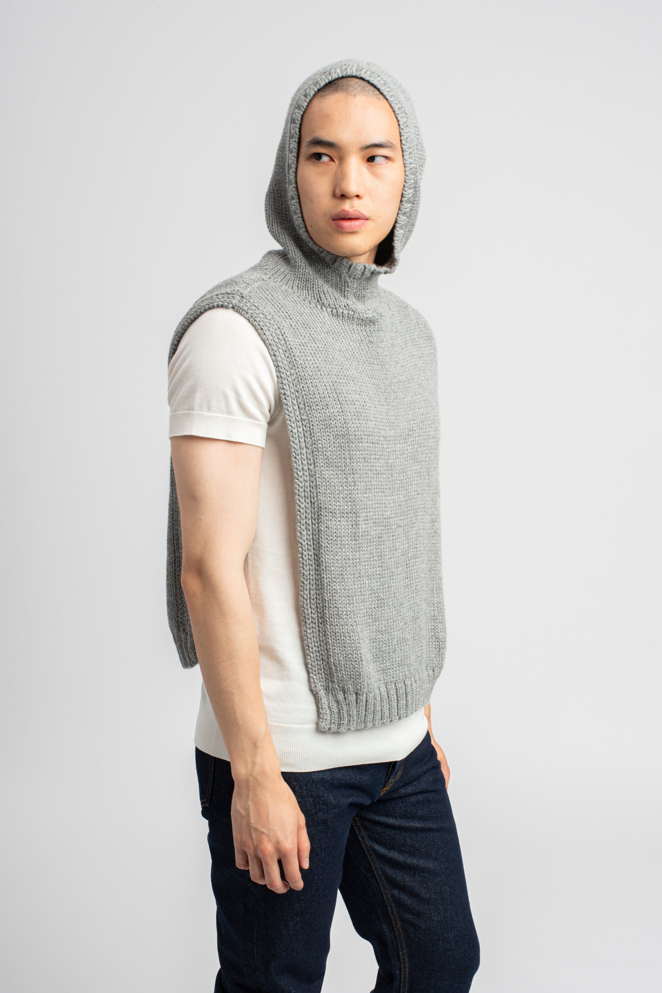 Model wearing poncho in light grey alpaca wool with hood