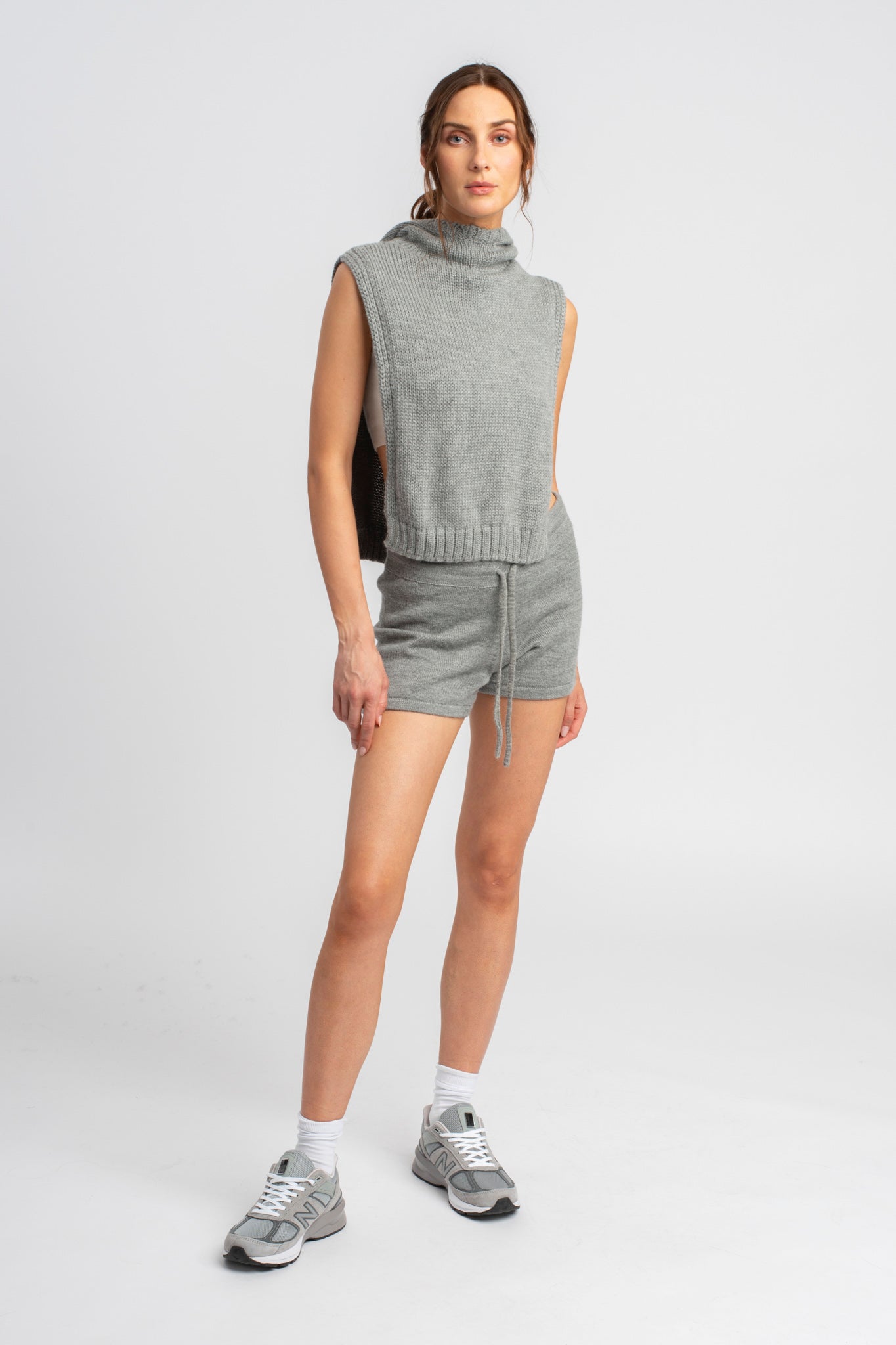 Model wearing poncho in light grey alpaca wool with matching shorts