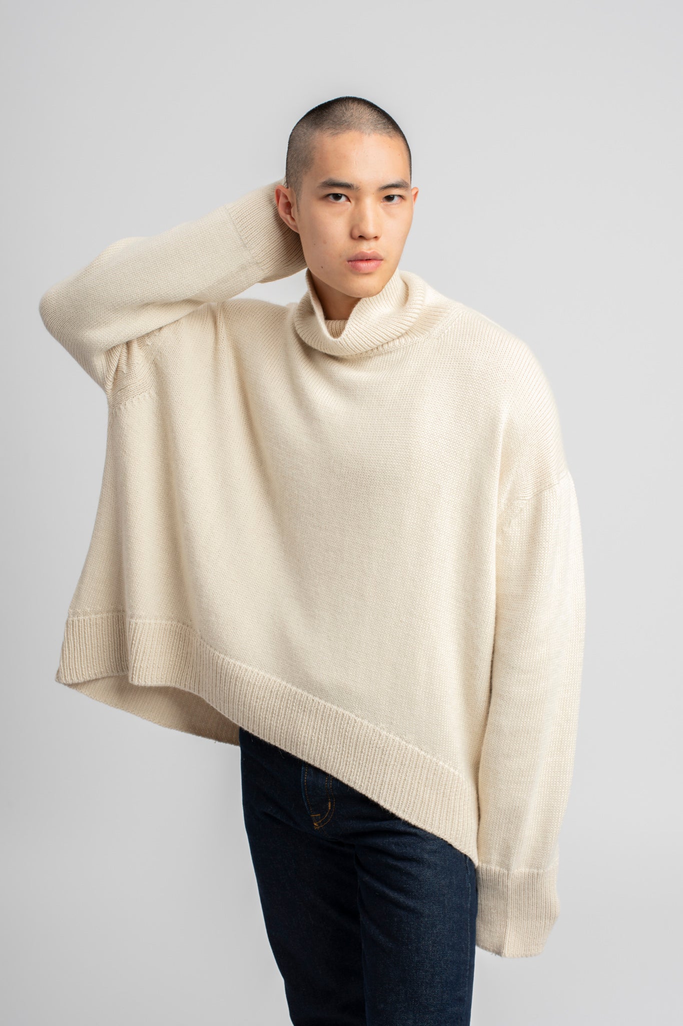 Model wearing turtleneck oversized sweater in white alpaca wool, front