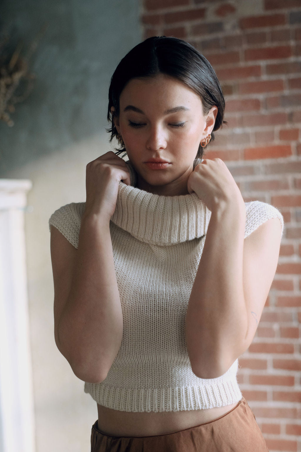 Model wearing white sweater crop top in alpaca wool, front close-up